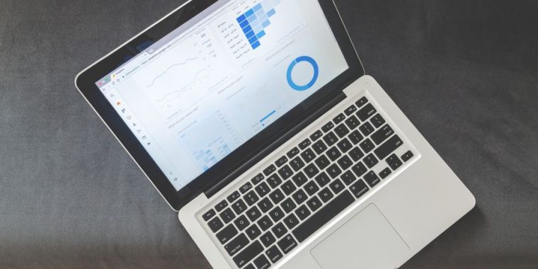 Overhead view of a laptop showing data visualizations and charts on its screen.