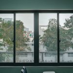 Serene view through a large window of an urban classroom, featuring trees and cityscape.