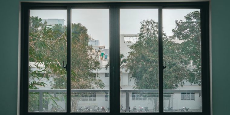 Serene view through a large window of an urban classroom, featuring trees and cityscape.