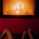 A warm, romantic moment by the fire with cozy socks and gentle lighting.